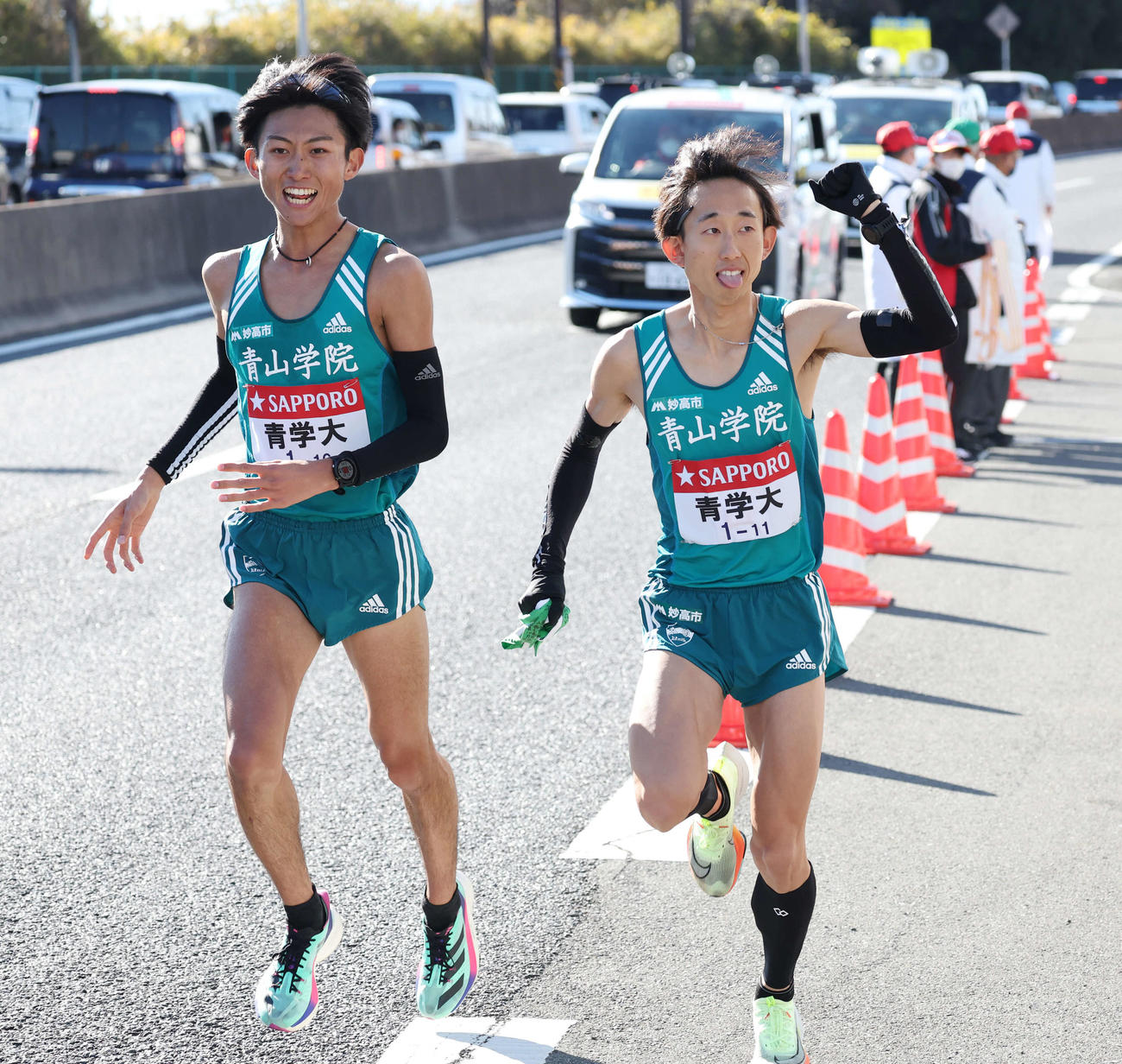 戸塚中継所で青学大8区田中（左）からたすきを受け走り出す9区岸本（撮影・宮地輝）