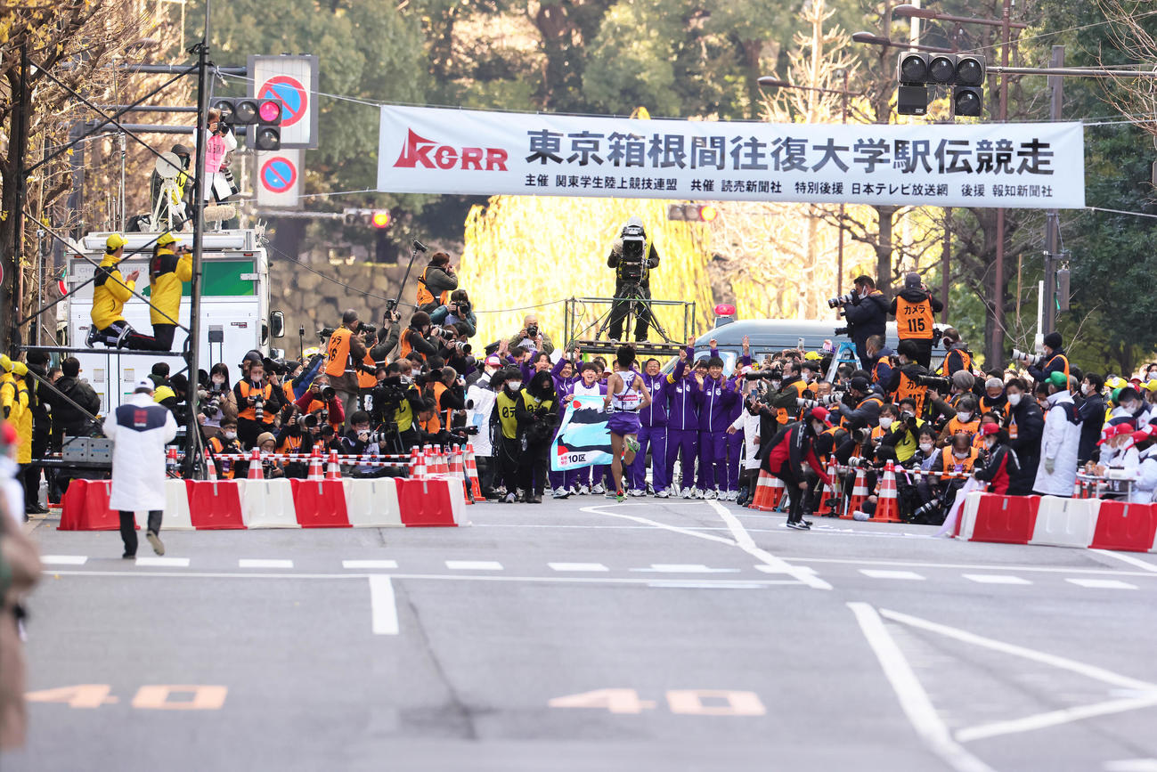 大学駅伝3冠を果たした駒大・大八木監督（中央右）らは10区青柿（手前）をガッツポーズで迎える（撮影・足立雅史）