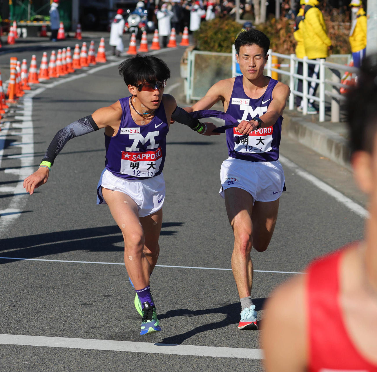 平塚中継所、10位でたすきをつなぐ明大7区杉（右）と8区加藤（代表撮影）