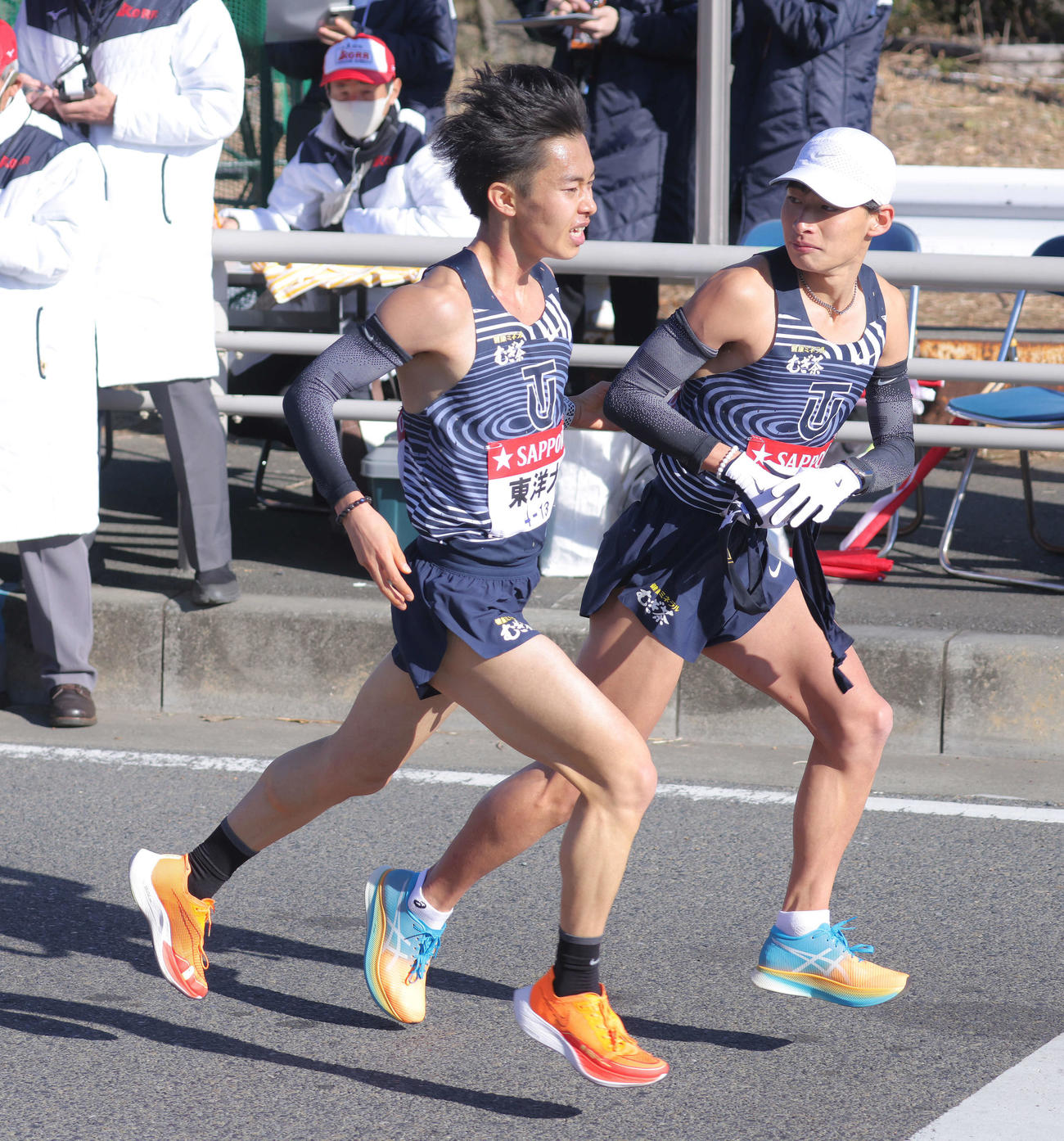 平塚中継所、12位でたすきをつなぐ東洋大7区佐藤（左）と8区木本（撮影・河田真司）