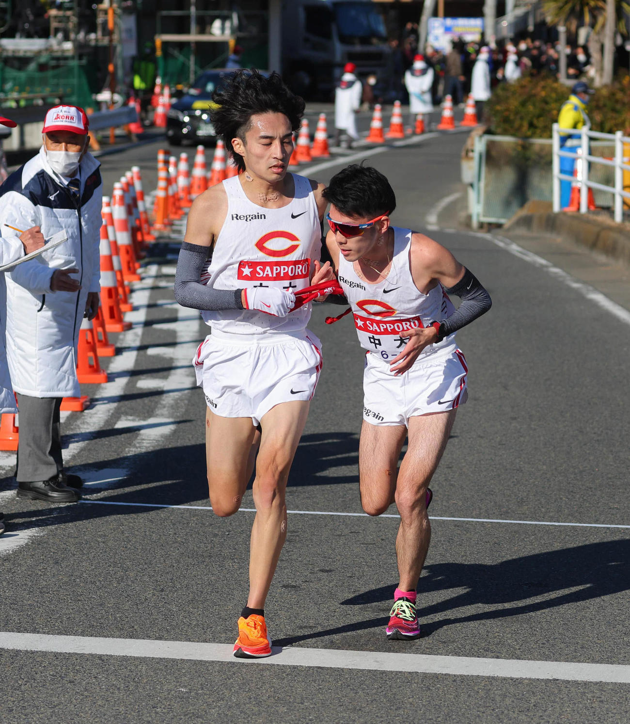 平塚中継所、2位でたすきをつなぐ中大7区千守（左）と8区中沢（代表撮影）