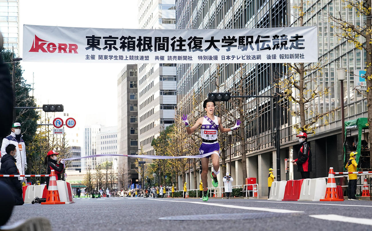 総合優勝を果たし、指で3と作りゴールする駒大10区青柿（撮影・菅敏）