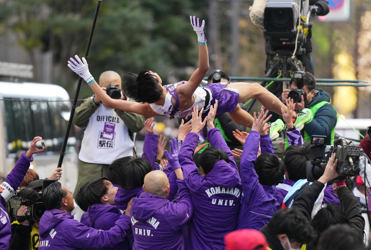 総合優勝を果たし、胴上げされる駒大10区青柿（上）（撮影・菅敏）