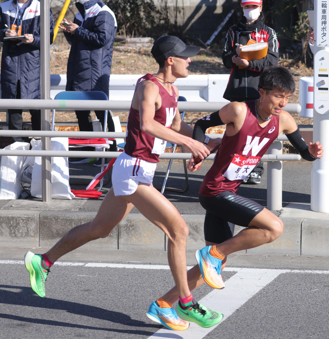 平塚中継所、4位でたすきをつなぐ早大7区鈴木（左）と8区伊福（撮影・河田真司）