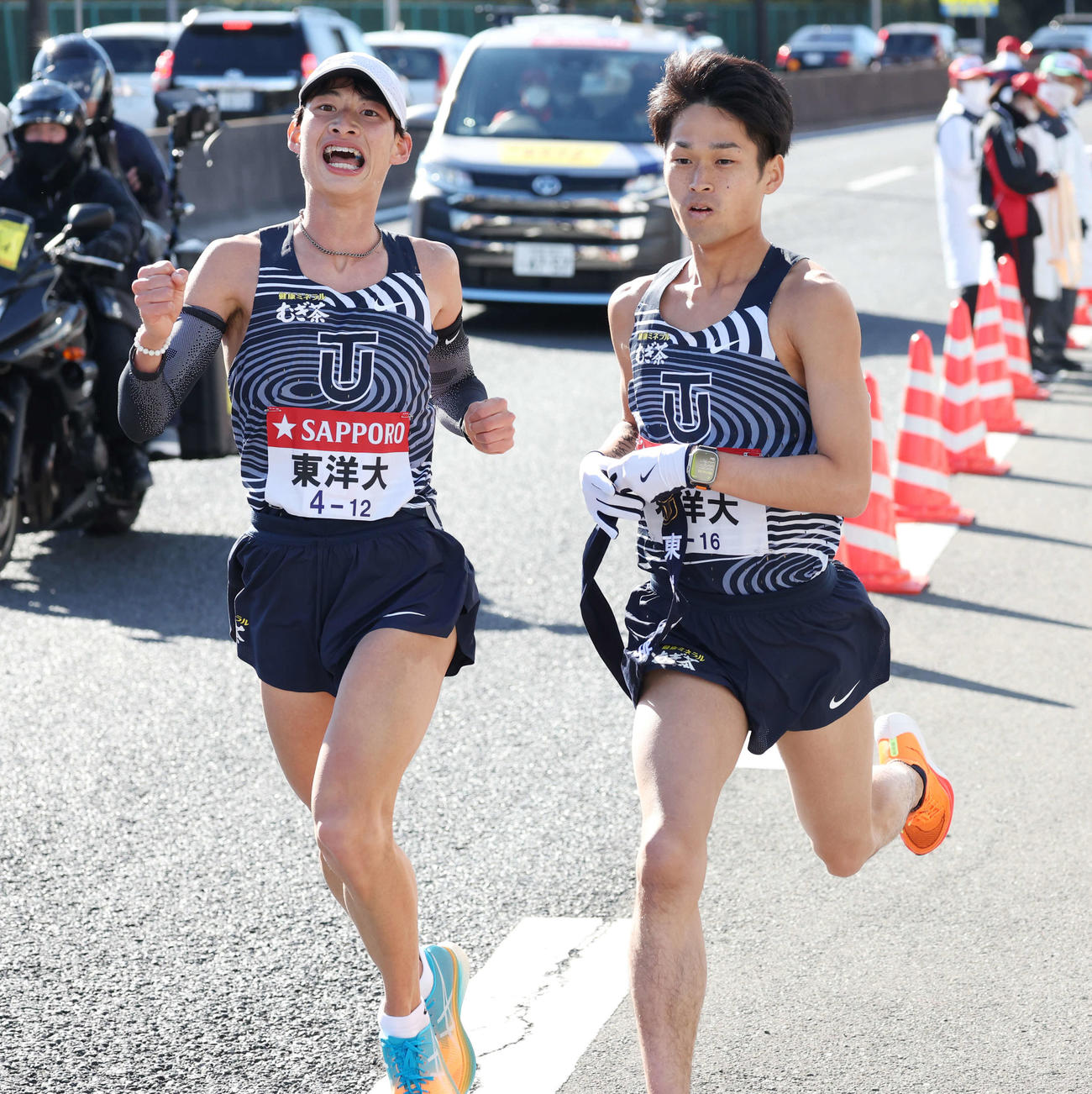 戸塚中継所で東洋大8区木本（左）からたすきを受け走り出す9区梅崎（撮影・宮地輝）
