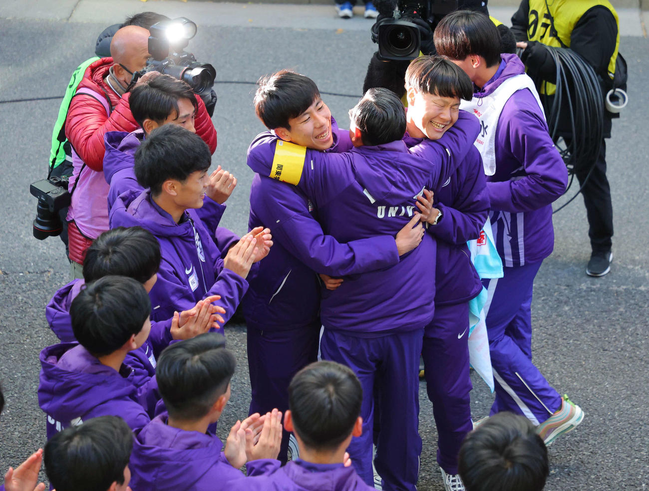 悲願の優勝を果たし、大八木監督（右から3人目）と抱き合う田沢（中央）ら駒大の選手たち（代表撮影）