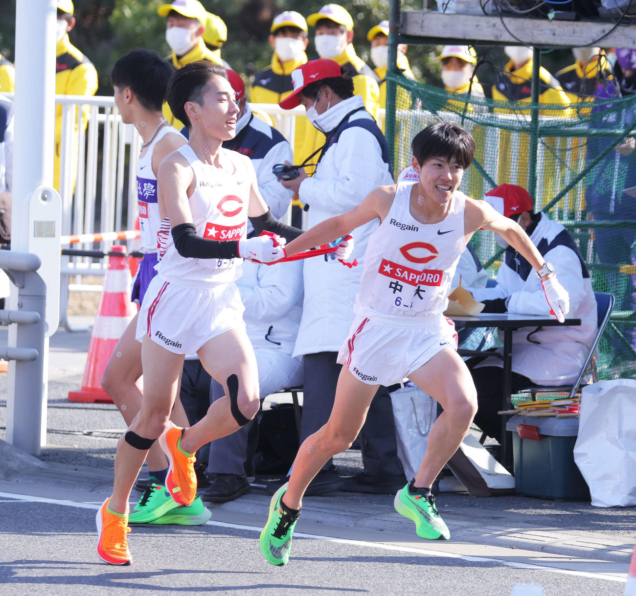 平塚中継所、1位でたすきをつなぐ中大3区中野と4区吉居（撮影・河田真司）