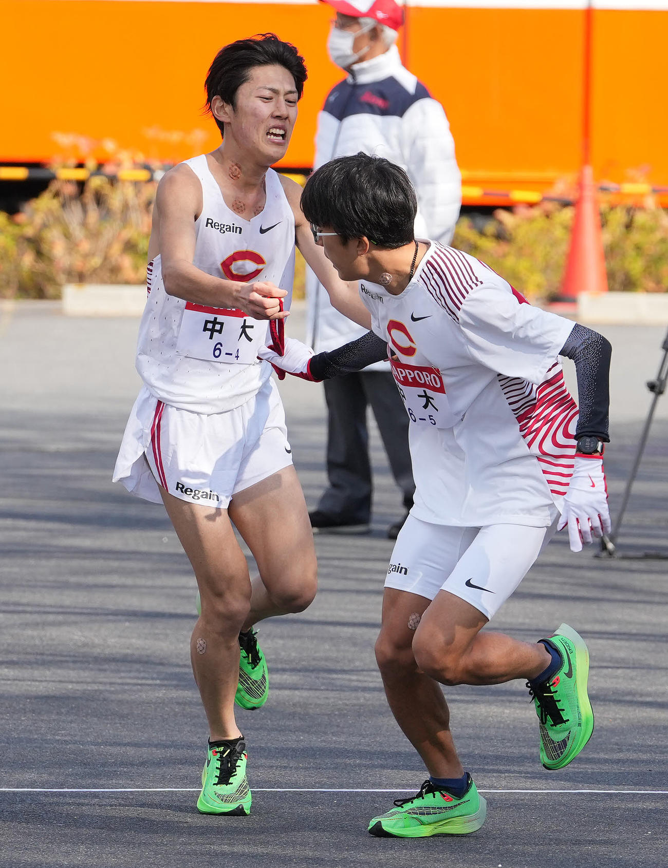 中大4区吉居は（左）小田原中継所で5区阿部にたすきを渡す（撮影・鈴木みどり）
