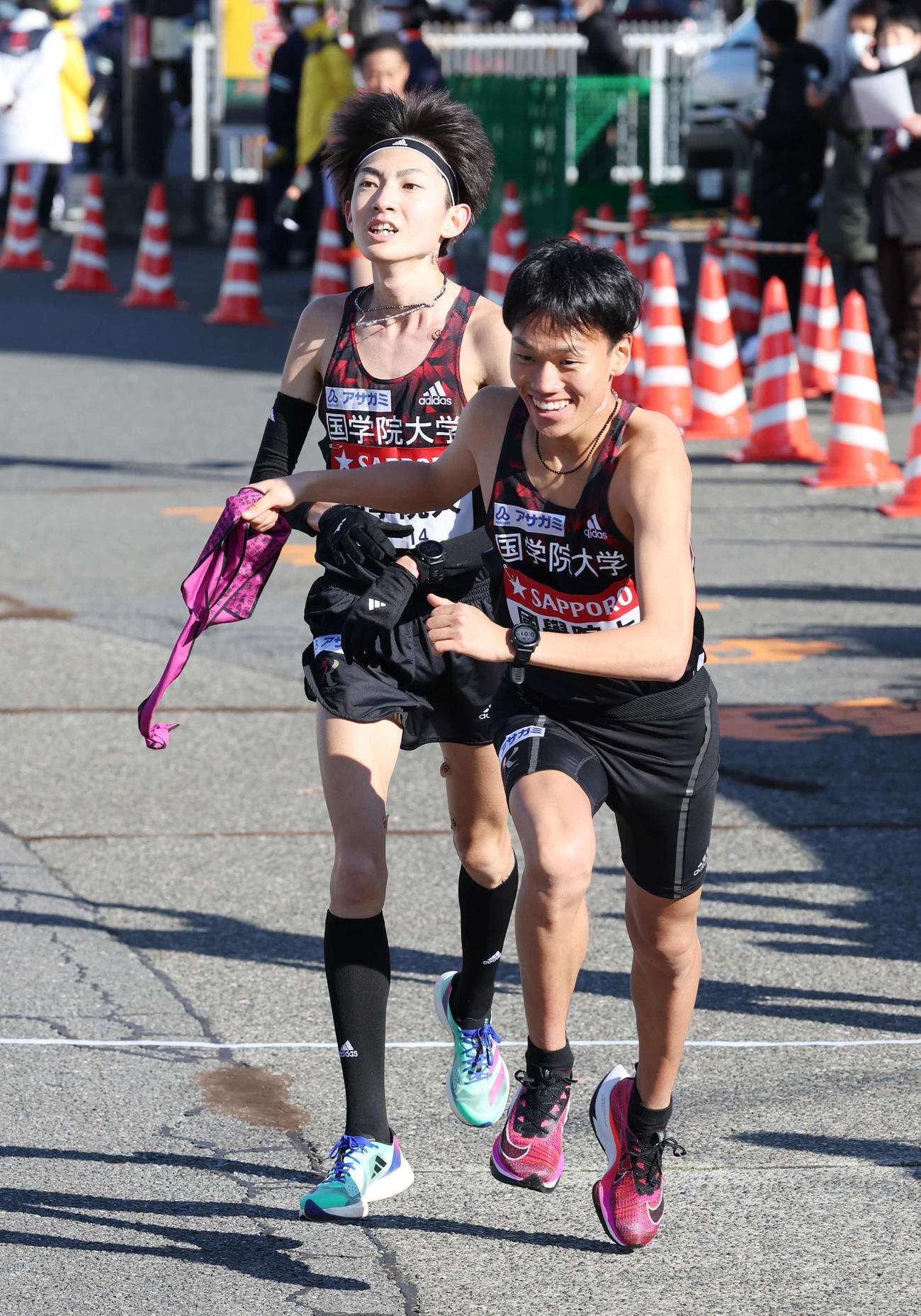 23年1月2日、戸塚中継所で国学院大2区平林清澄（左）は3区山本歩夢にたすきを渡す