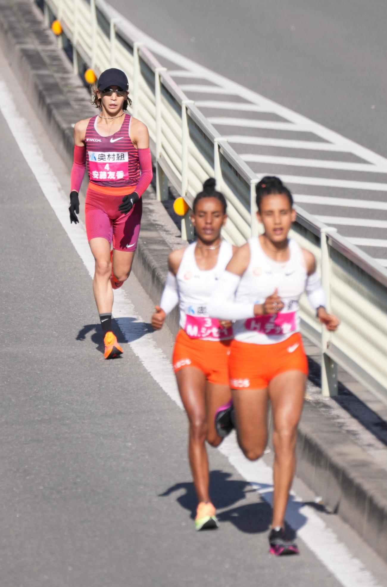 30キロ過ぎ、遅れるをとる安藤友香（奥）。先頭争いをするヘヴン・ハイル・デッセ（手前右）とメセレット・ゴラ・シセイ（代表撮影）