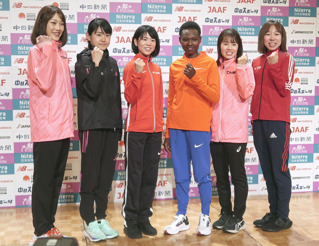 記者会見でポーズをとる鈴木亜由子（左から3人目）、前田穂南（左端）ら（共同）