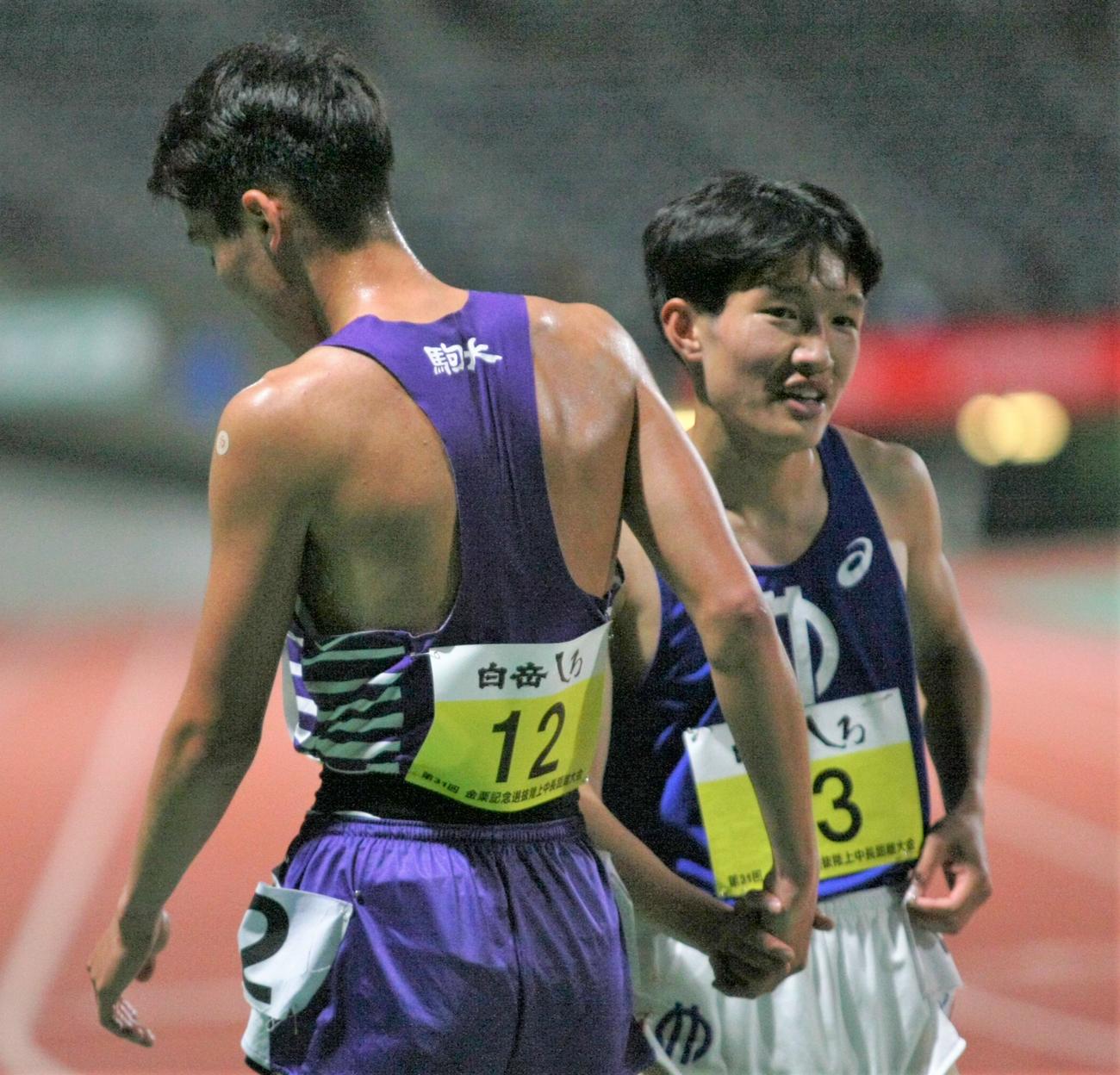 金栗記念選抜中長距離大会の男子5000メートルを走り終え、握手を交わす駒大・佐藤（左）と順大・吉岡（撮影・藤塚大輔）