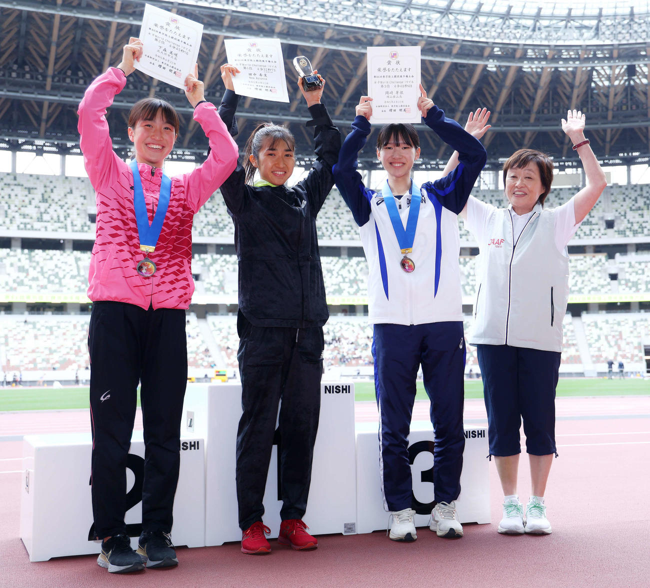 女子1マイル決勝の表彰式で写真に納まる、左から2位の下森、1位の田中、3位の岡崎、東京陸上競技協会増田会長（撮影・河田真司）