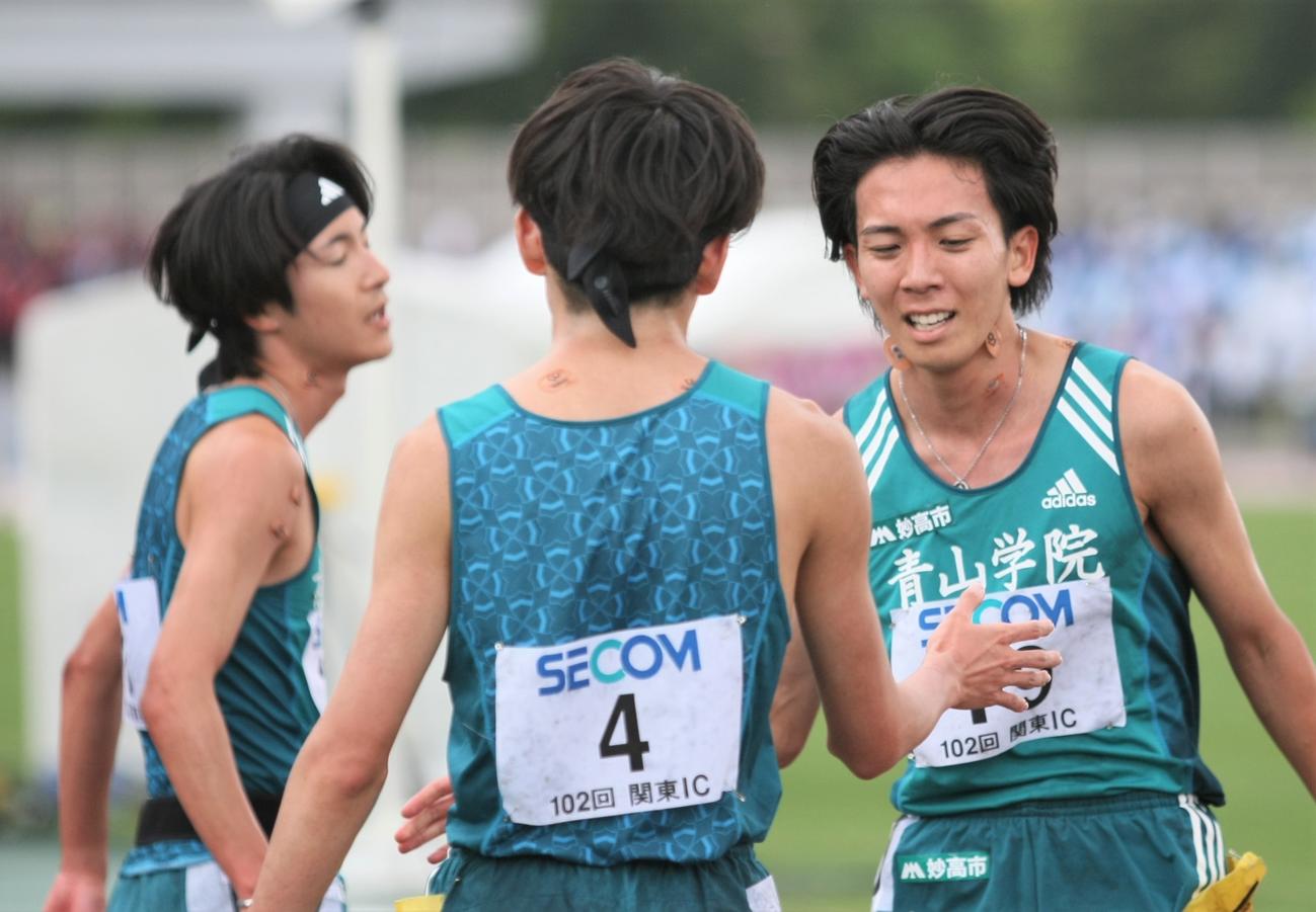 陸上関東インカレ男子2部5000メートル決勝　日本人選手トップとなる3位に入り、チームメートと握手を交わす青学大・鶴川（右）（撮影・藤塚大輔）