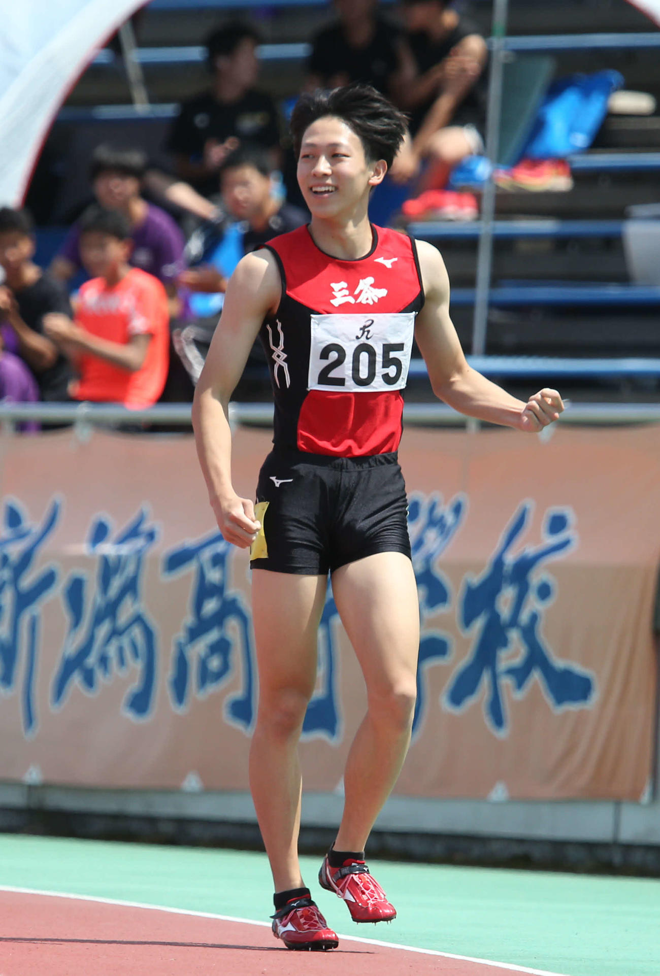 100メートル準決勝で、県高校新記録を出した三条・鶴巻は笑顔で拳を握る