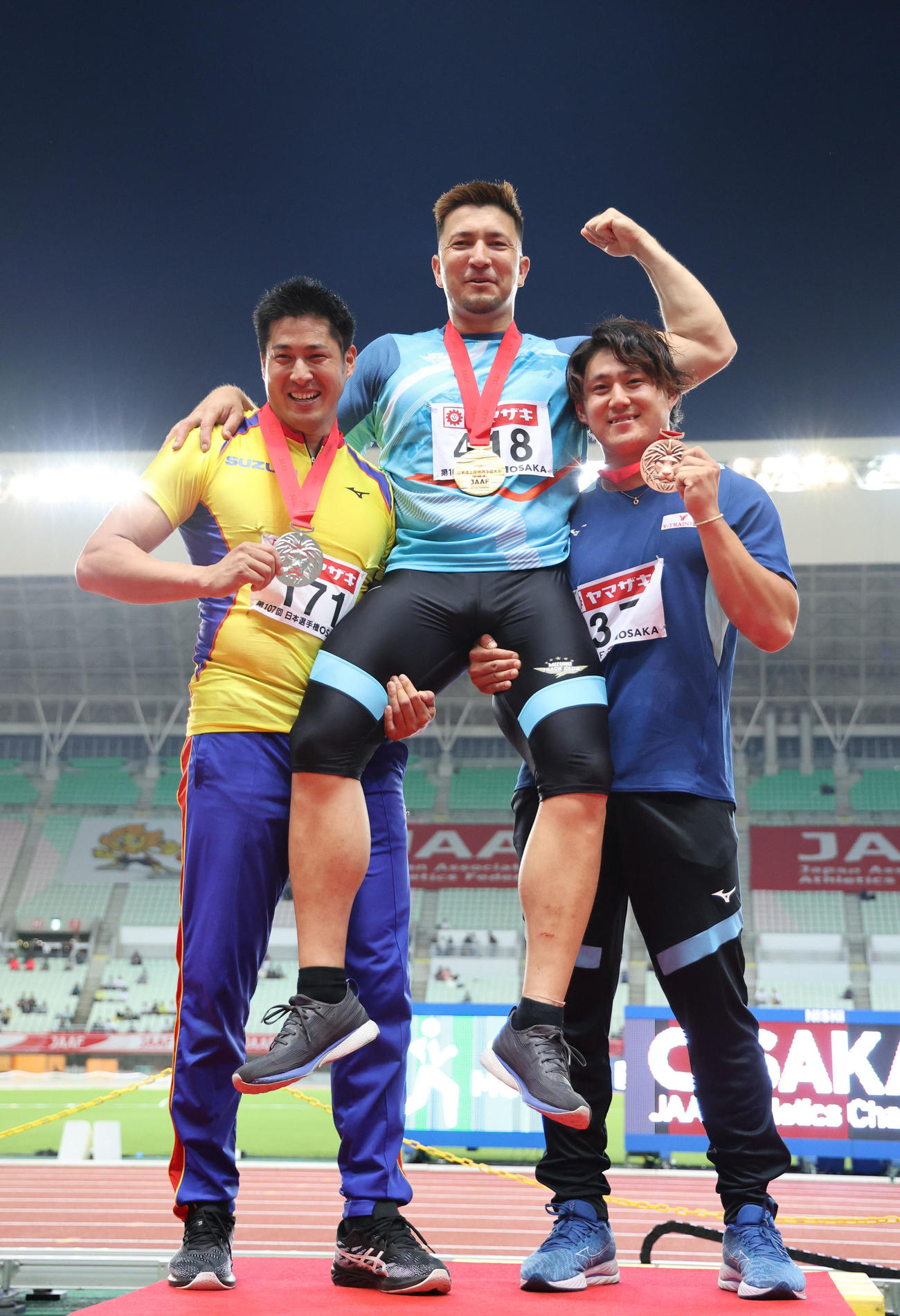 2023年6月31日、日本陸上競技選手権大会　男子やり投げの表彰式で優勝したディーン（中央）を担ぐ、2位の新井（左）、3位の崎山