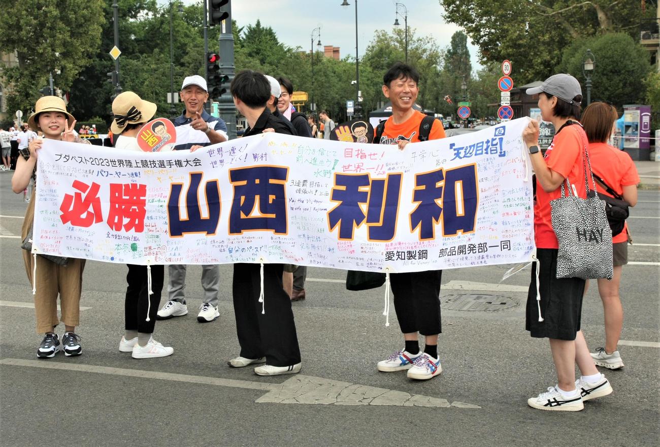 陸上世界選手権男子20キロ競歩の発着地点となる英雄広場で山西の横断幕を広げるファン（撮影・藤塚大輔）