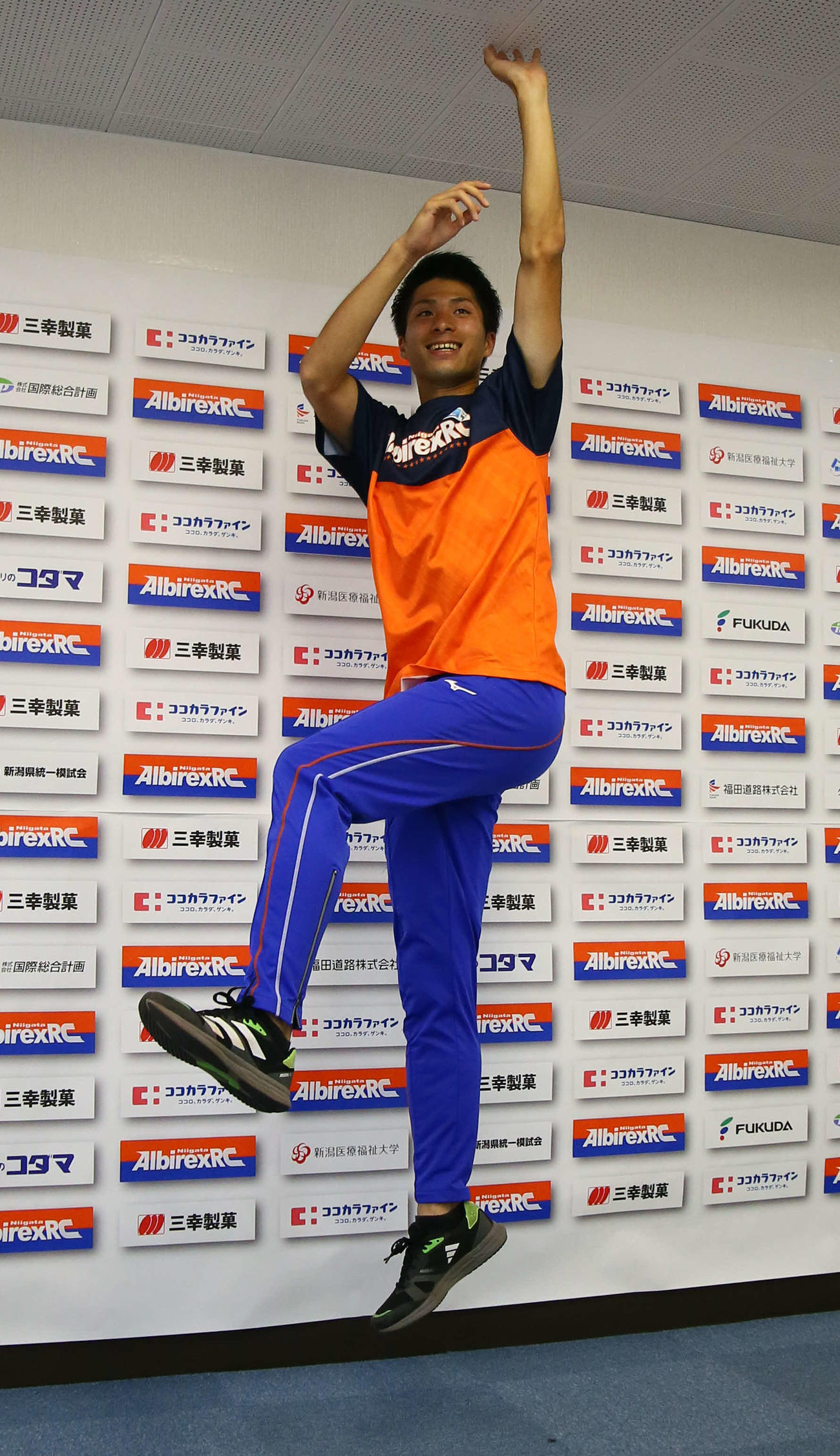 ジャンプして天井に手をつく長谷川