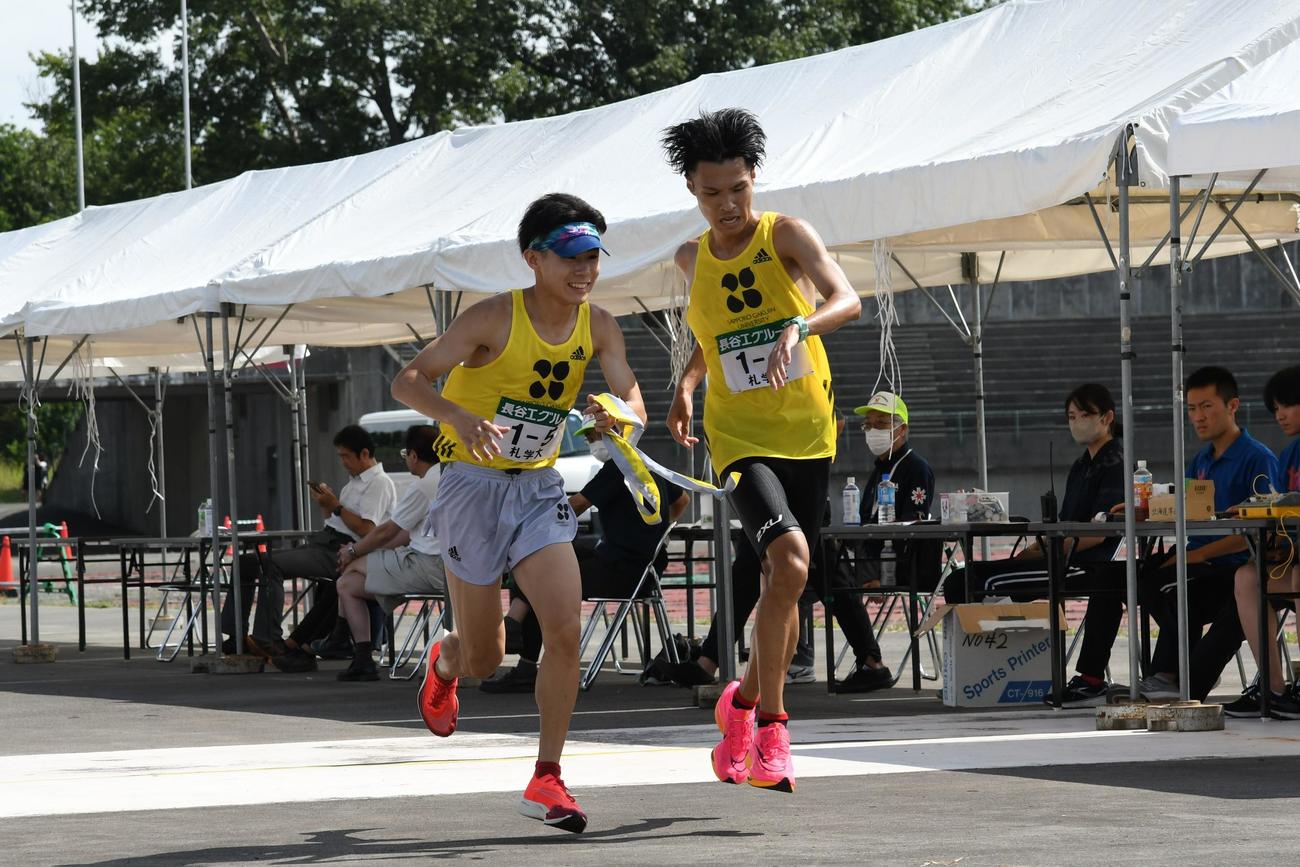 タスキを受け取る札幌学院大・佐藤魁（左）と大柳（撮影・石井翔太）