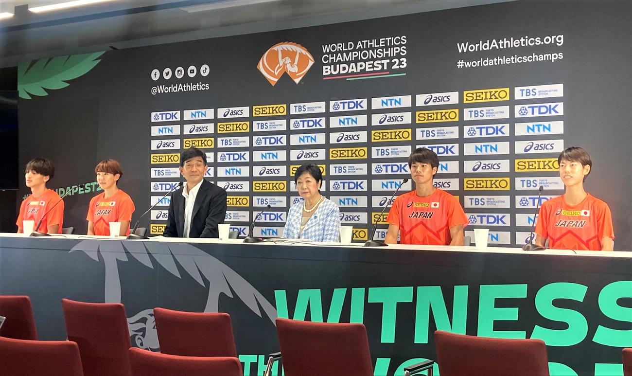 陸上の世界選手権の開催地であるハンガリー・ブダペストを訪問し、スタジアムで会見に臨む小池百合子東京都知事（左から4人目）。そのほか左から橋岡、寺田、日本陸連の尾県会長、1人空けて池田、広中（撮影・藤塚大輔）