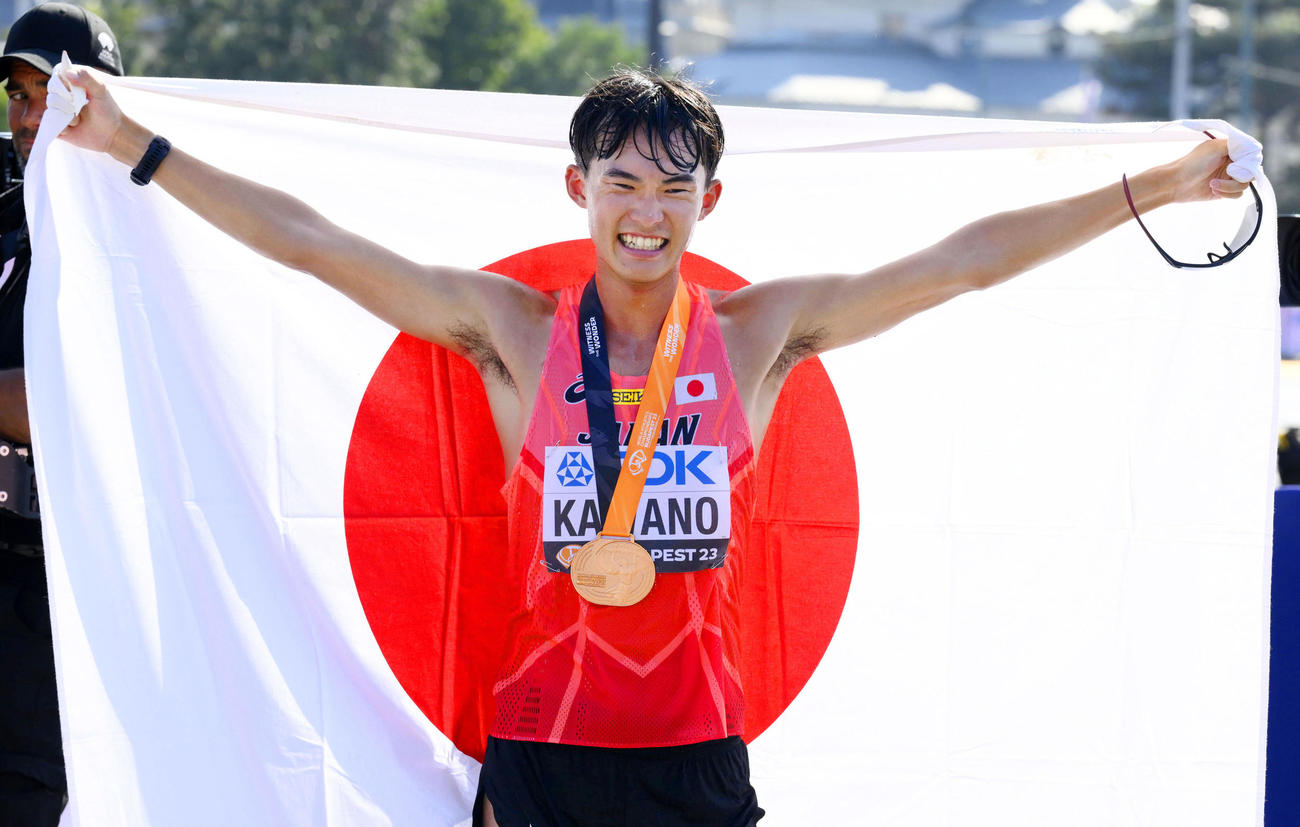 陸上の世界選手権男子男子35キロ競歩で銅メダルを獲得し、日の丸を掲げる川野（共同）