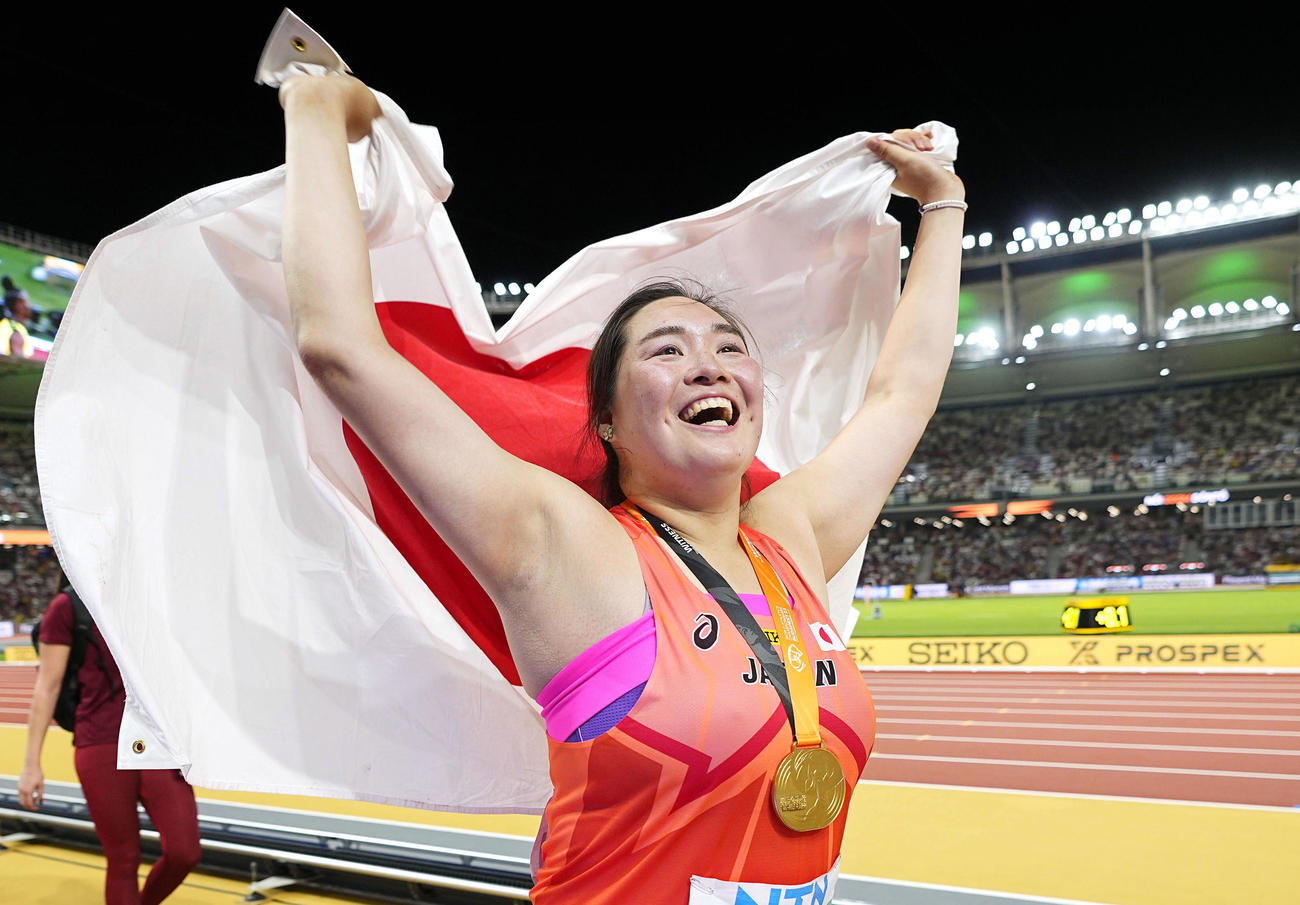 陸上の世界選手権女子やり投げで金メダルを獲得し、日の丸を掲げる北口（共同）