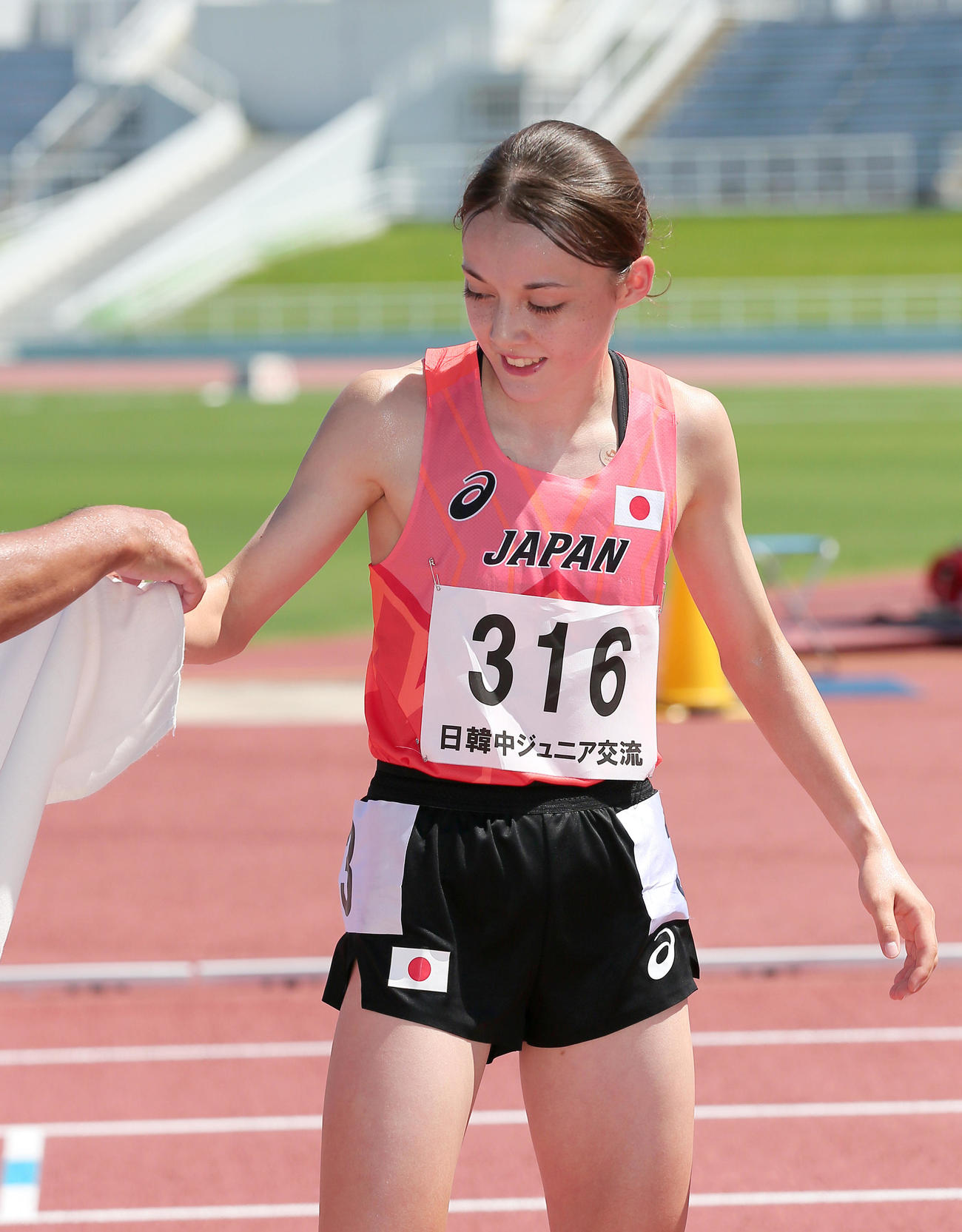 女子1500メートルで優勝のドルーリー朱瑛里は係員から日の丸を渡され笑顔を見せる（撮影・上山淳一）