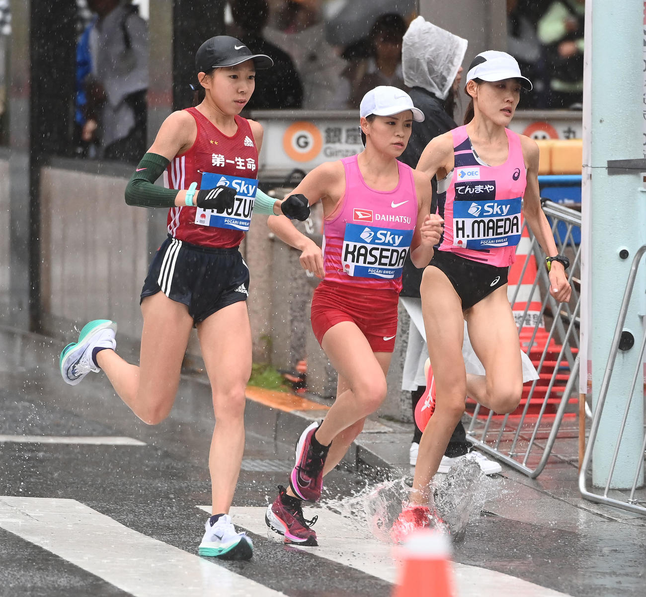 水しぶきを上げながら、銀座4丁目交差点を駆け抜けるMGC女子の鈴木優（左）。右から前田穂、加世田（撮影・たえ見朱実）