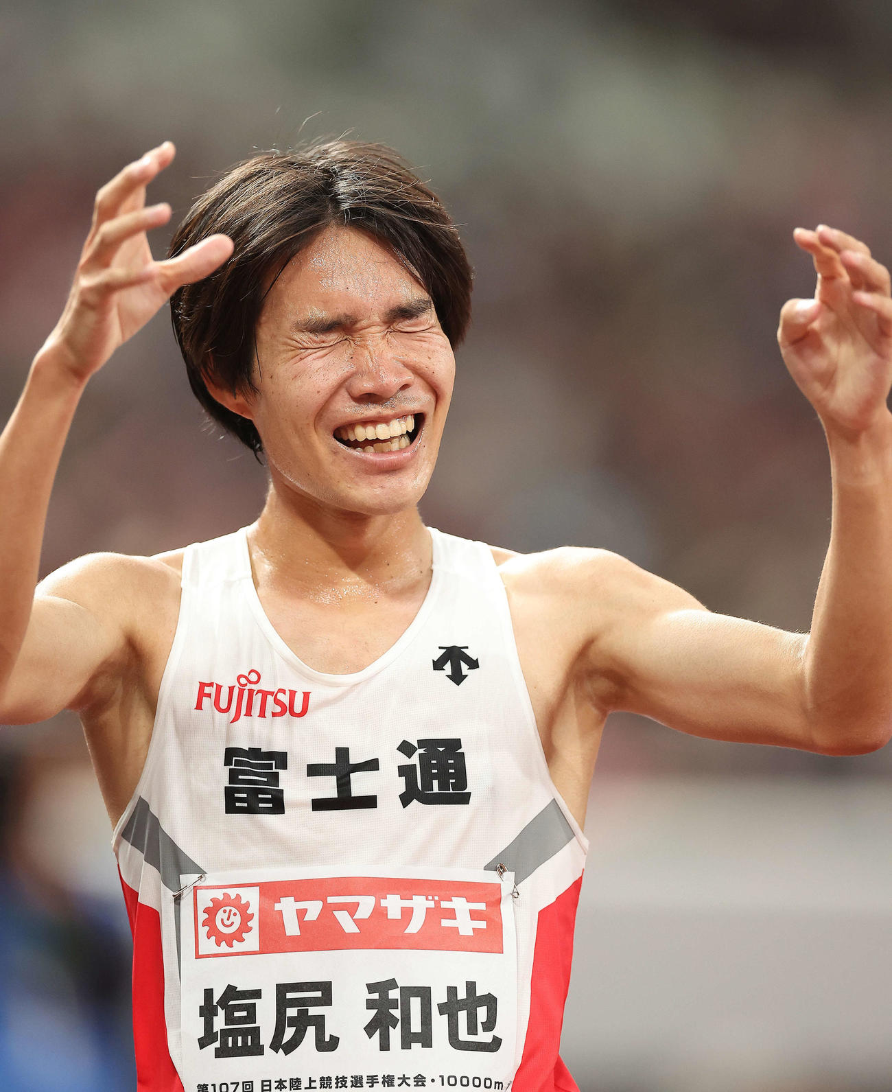 男子1万メートル　27分9秒80の日本新記録でフィニッシュし笑顔を見せる塩尻（撮影・河田真司）