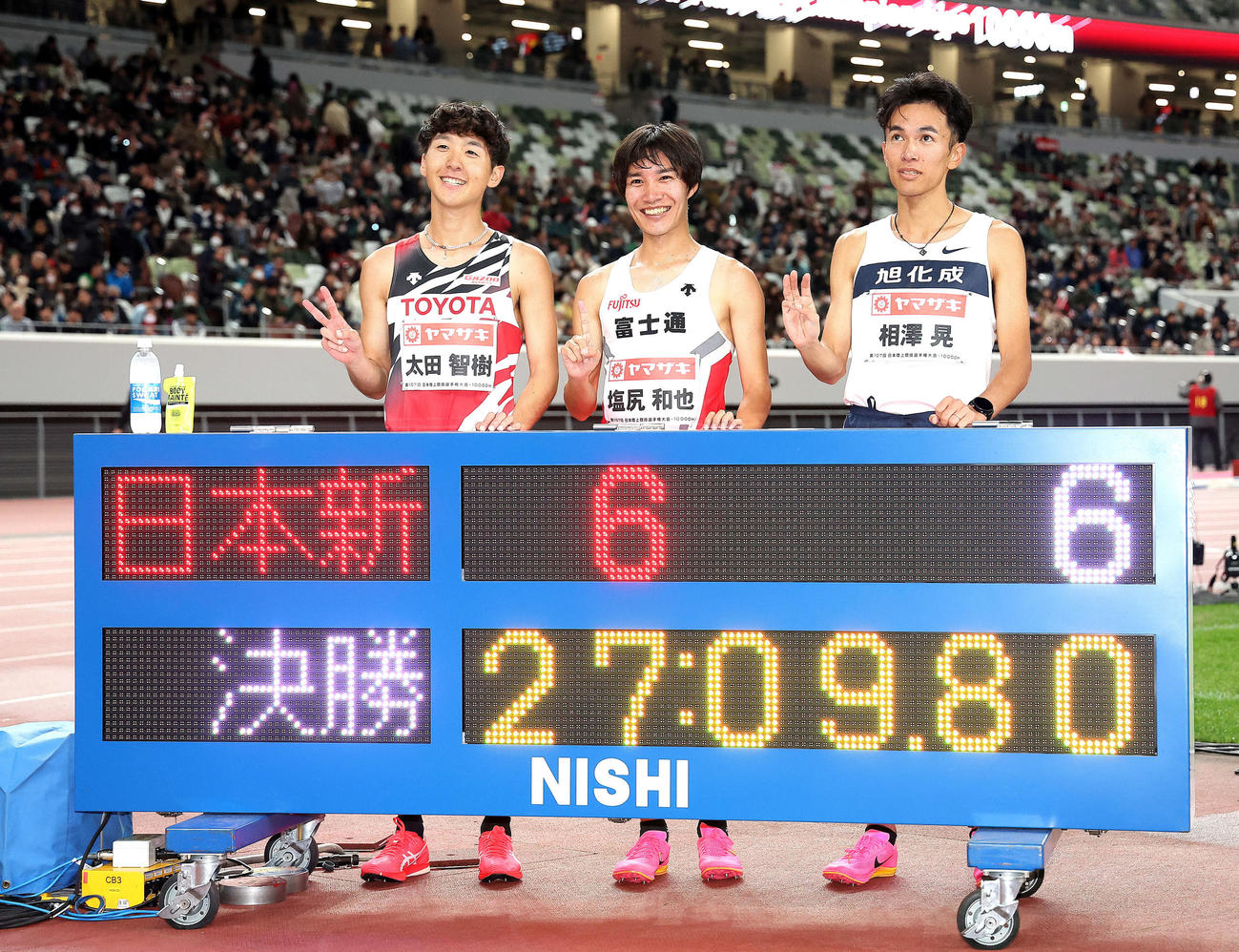 男子1万メートル　日本新記録で優勝を果たし、2位太田（左）3位の相沢（右）と写真に納まる塩尻（撮影・河田真司）