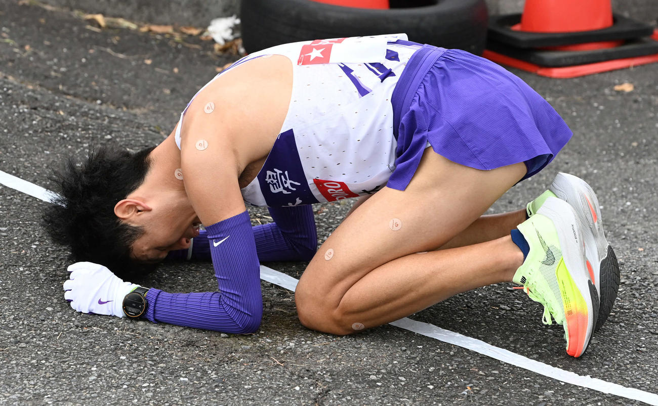 戸塚中継所にトップで到着した駒大2区鈴木は倒れ込む（撮影・山崎安昭）