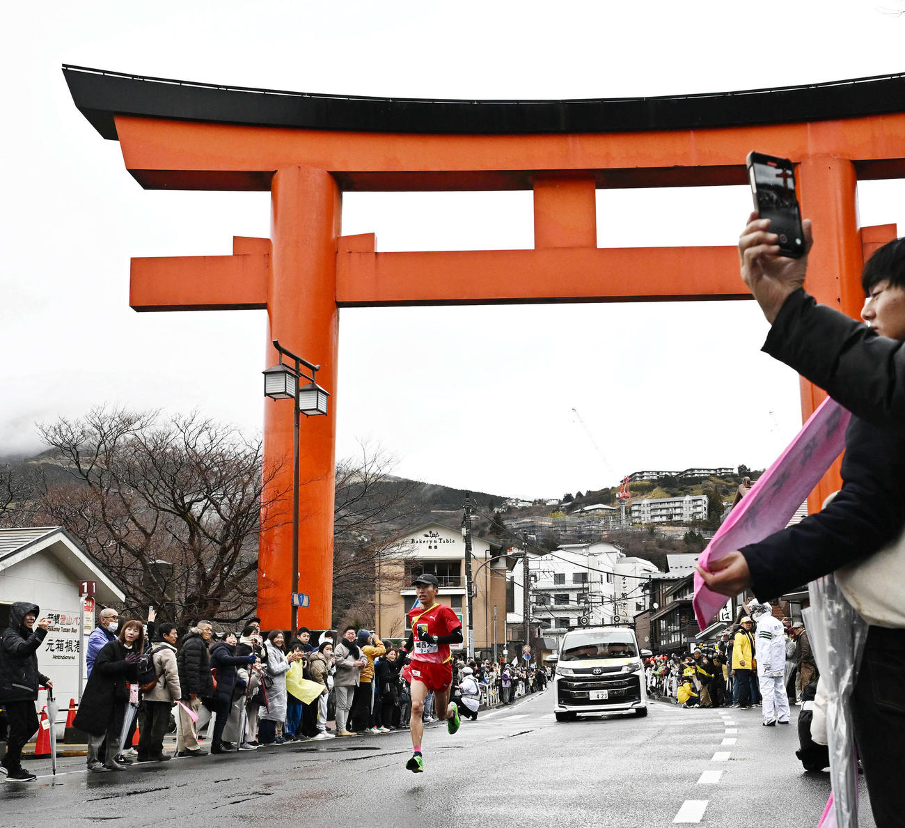 箱根神社の大鳥居を走り抜ける城西大5区山本（撮影・滝沢徹郎）