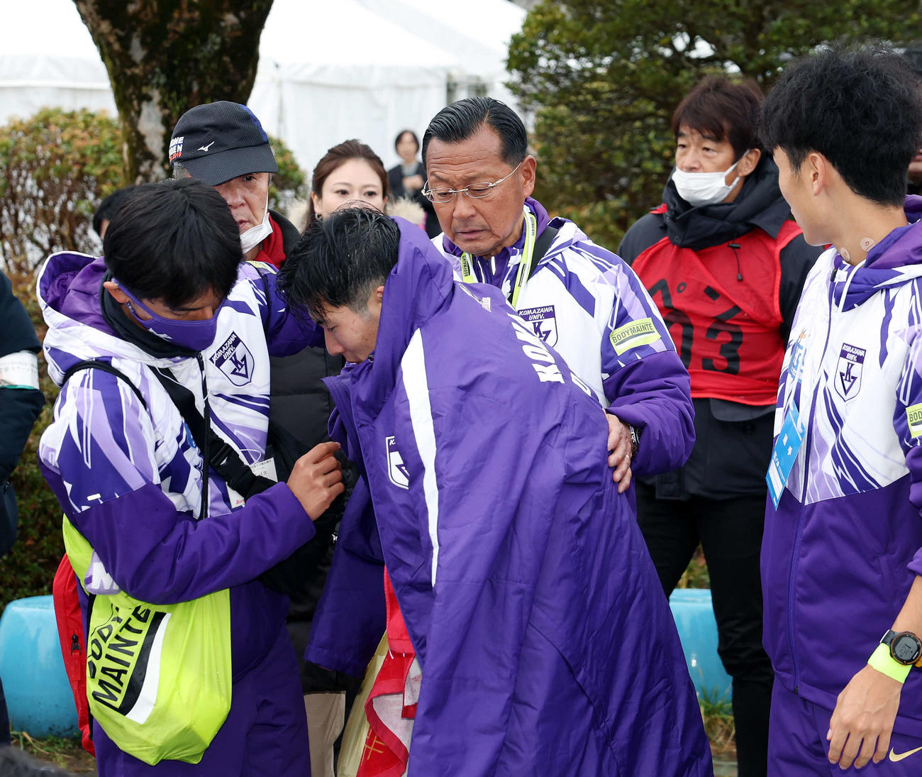 2位でゴールした駒大5区金子（中央手前）に上着を着せる大八木総監督（同後方）（撮影・宮地輝）