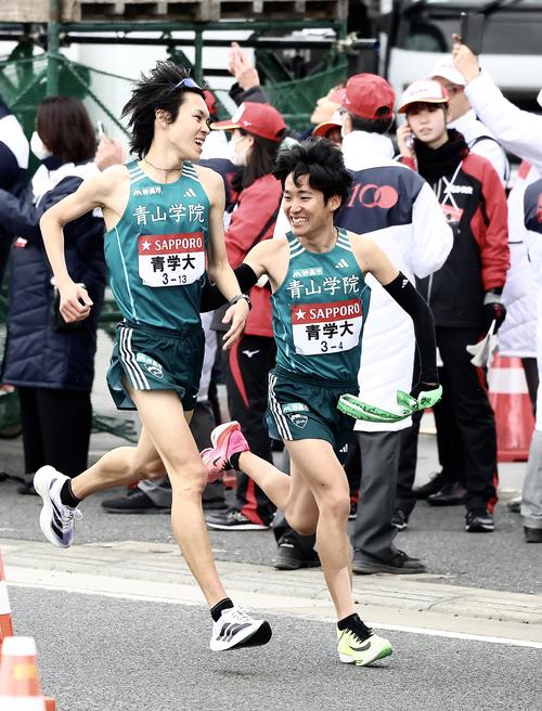 平塚中継所、青学大3区太田（左）は1位で4区佐藤にたすきを渡す（撮影・河田真司）