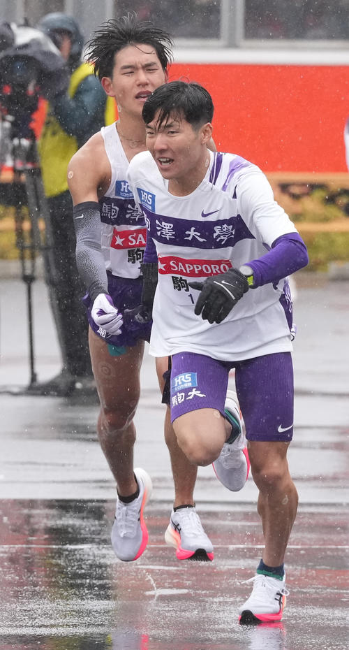 駒大4区山川（左）は小田原中継所で5区金子にたすきを渡す（撮影・鈴木みどり）