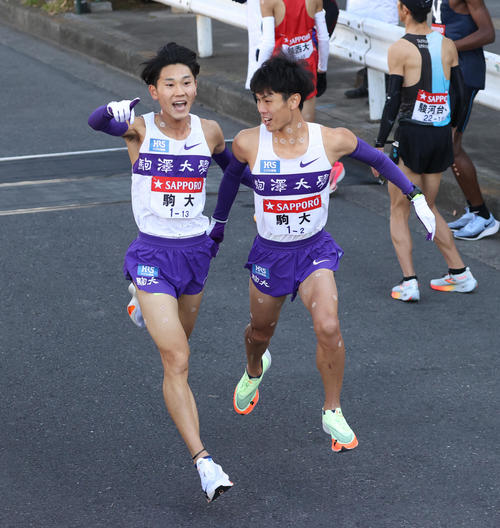 箱根駅伝　駒大1区篠原（左）は2区鈴木にたすきを渡す（撮影・大野祥一）