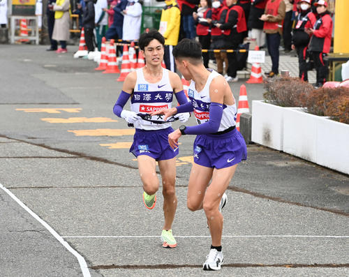 戸塚中継所にトップで駆け込む駒大2区鈴木（左）（撮影・山崎安昭）