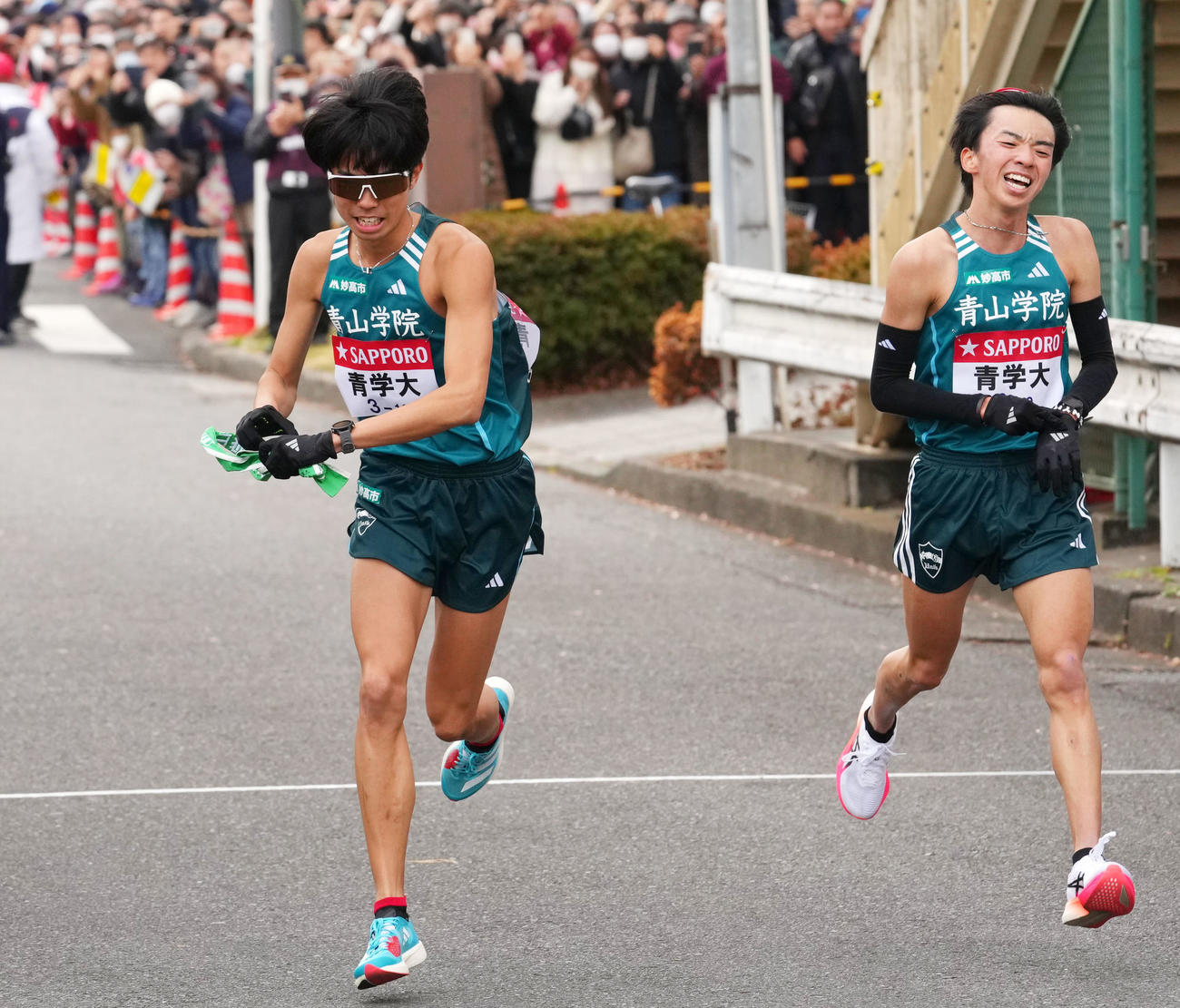 鶴見中継所で青学大9区倉本（右）からたすきを受け走り出す10区宇田川（撮影・横山健太）