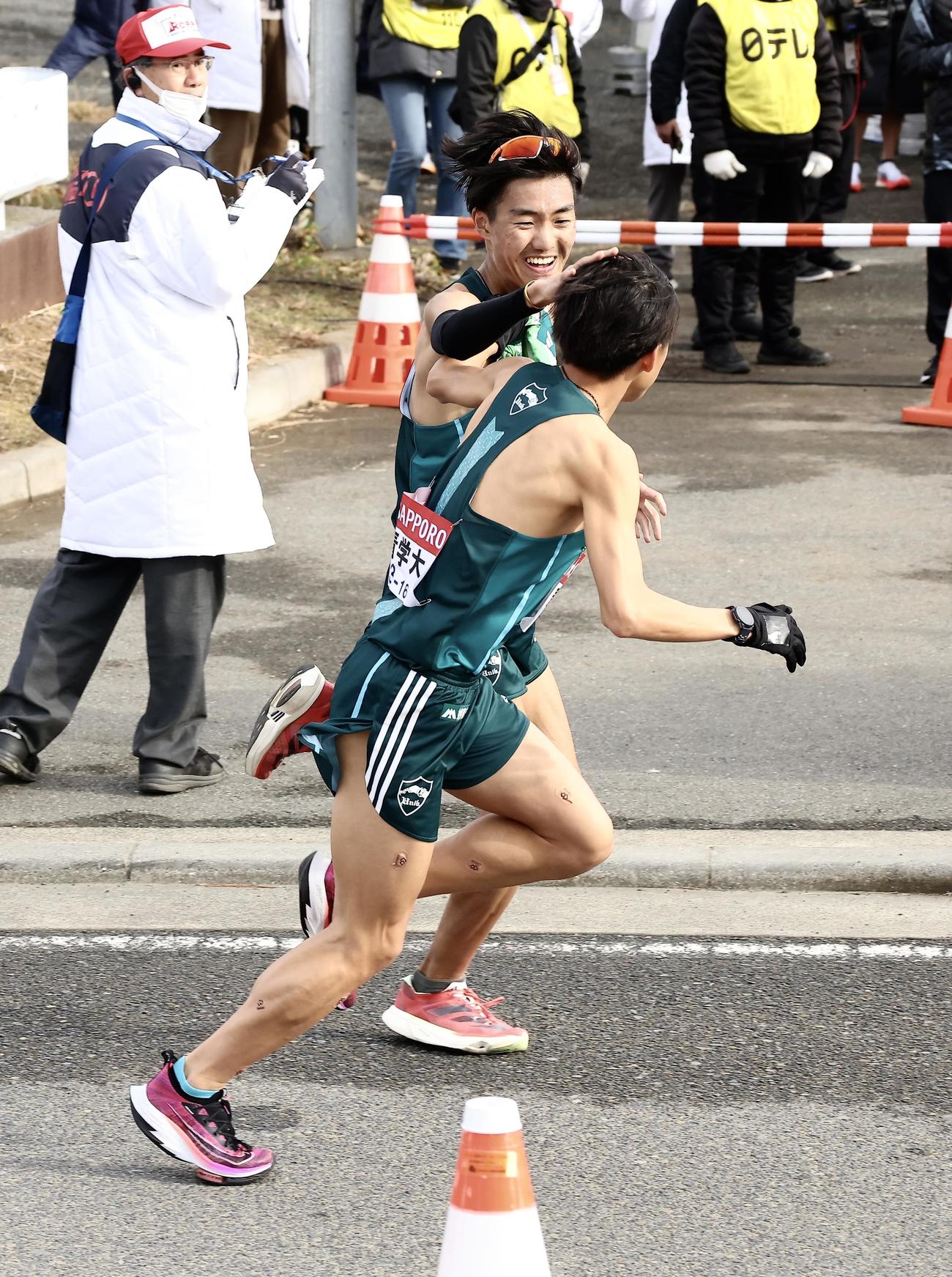 平塚中継所、青学大7区山内（奥）は1位で8区塩出にたすきを渡す（撮影・河田真司）