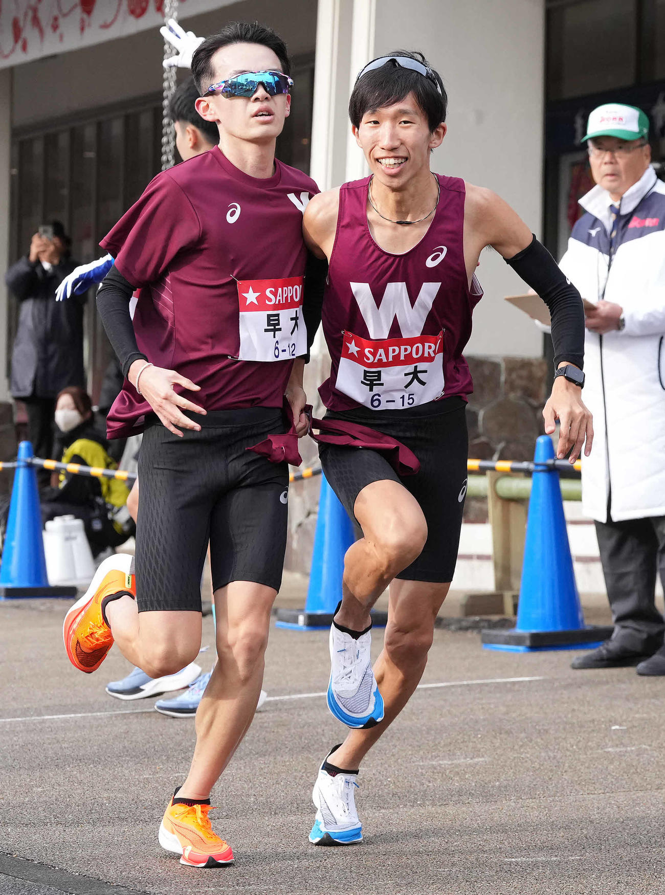 小田原中継所で7区諸冨（右）にたすきを渡す早大6区柳本（撮影・鈴木みどり）