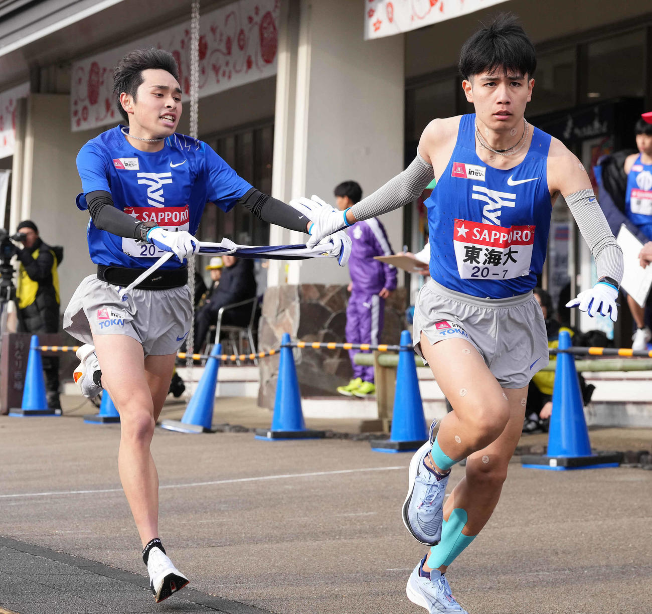 小田原中継所で7区石原（右）にたすきを渡す東海大6区梶谷（撮影・鈴木みどり）