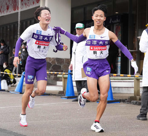 小田原中継所で7区安原（右）にたすきを渡す駒大6区帰山（撮影・鈴木みどり）