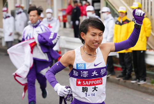 鶴見中継所で駒大9区花尾恭輔（左）からタスキを受け走り出す10区庭瀬（撮影・横山健太）