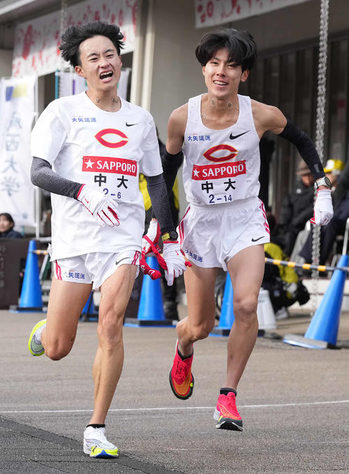 小田原中継所で7区吉居（右）にたすきを渡す中大6区浦田（撮影・鈴木みどり）