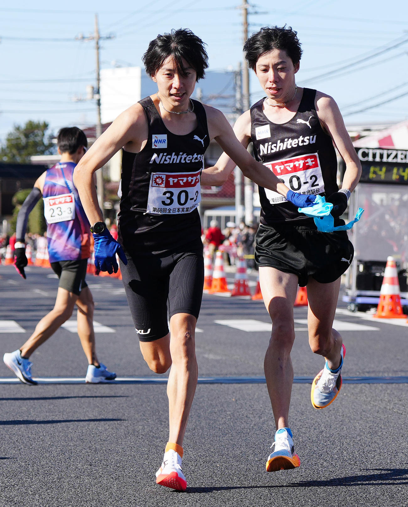 第2中継所でタスキリレーする西鉄・設楽兄弟。右は弟の2区悠太、左は3区の啓太（撮影・江口和貴）