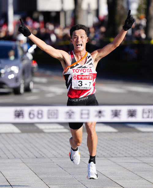 ニューイヤー駅伝で歓喜し優勝のゴールテープへ向かうトヨタ自動車7区の服部（撮影・江口和貴）