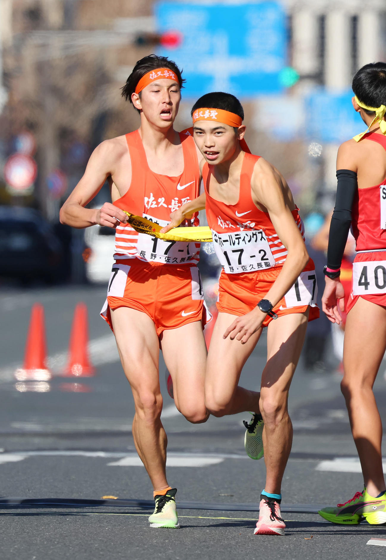 4位でたすきをつなぐ佐久長聖1区の永原（左）と2区の遠藤（撮影・前田充）