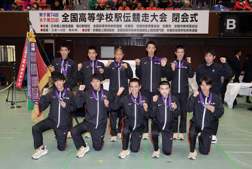 大会記録で優勝を果たし、笑顔で集合写真に納まる佐久長聖の選手たち。前列右から1区永原、2区遠藤、3区山口、4区浜口、5区佐々木、後列右から高見沢監督、6区吉岡、7区篠、小名、松山、小林（撮影・前田充）