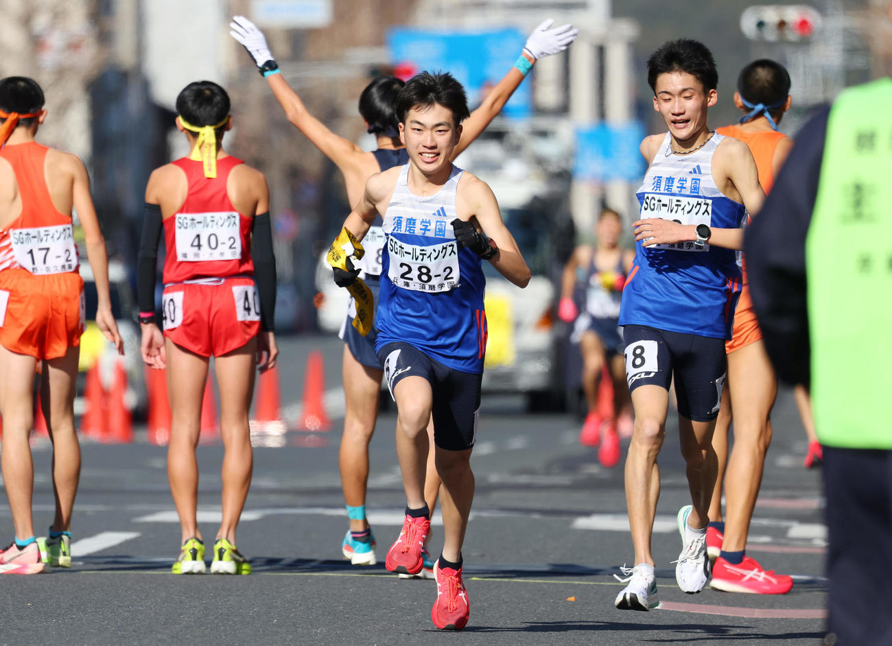1位でたすきを受け取り力走する須磨学園2区の藤岡（中央）。右は1区の折田（撮影・前田充）