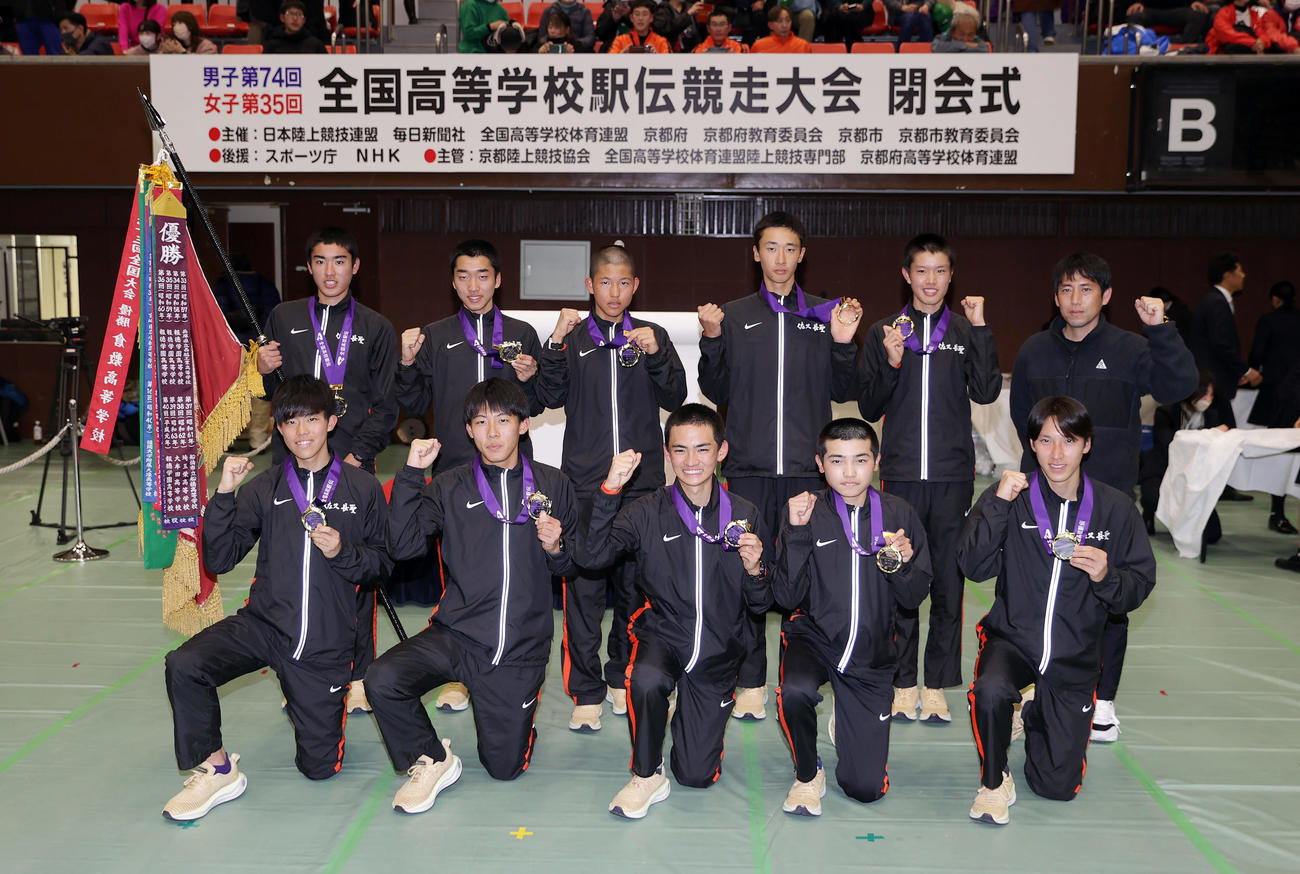 大会記録で優勝を果たし、笑顔で集合写真に納まる佐久長聖の選手たち。前列右から1区永原、2区遠藤、3区山口、4区浜口、5区佐々木、後列右から高見沢監督、6区吉岡、7区篠、小名、松山、小林（撮影・前田充）